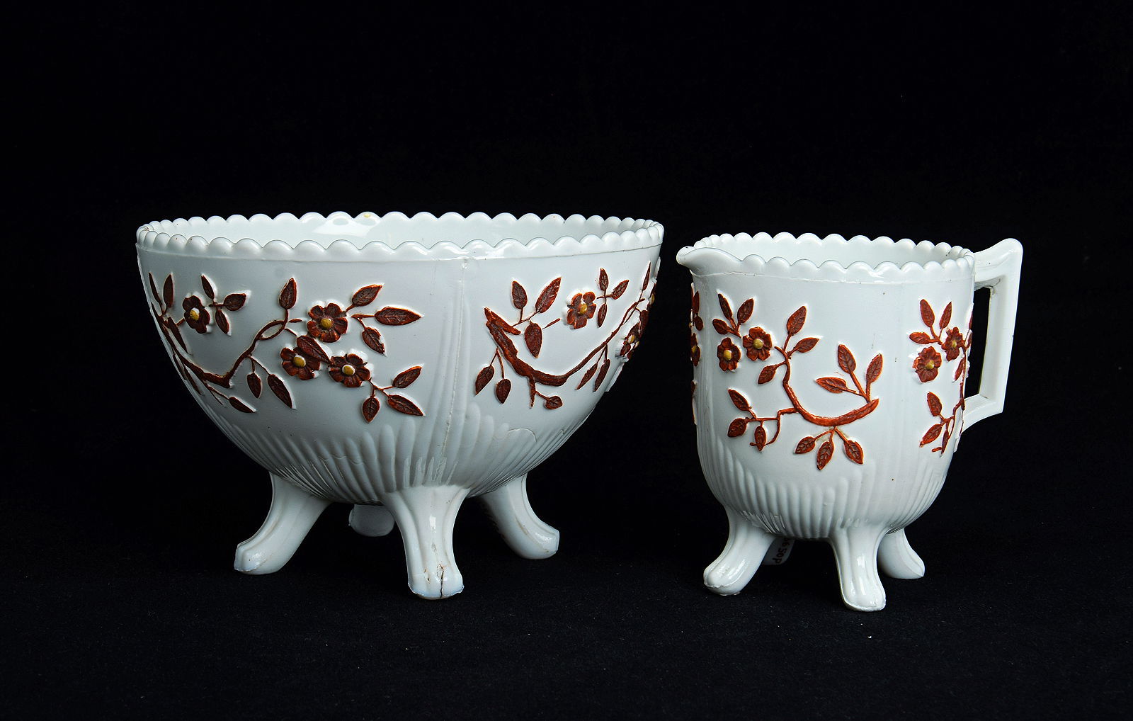 Sowerby opal white, cream jug and sugar bowl decorated with flowers picked out in brick red and mustard enamel