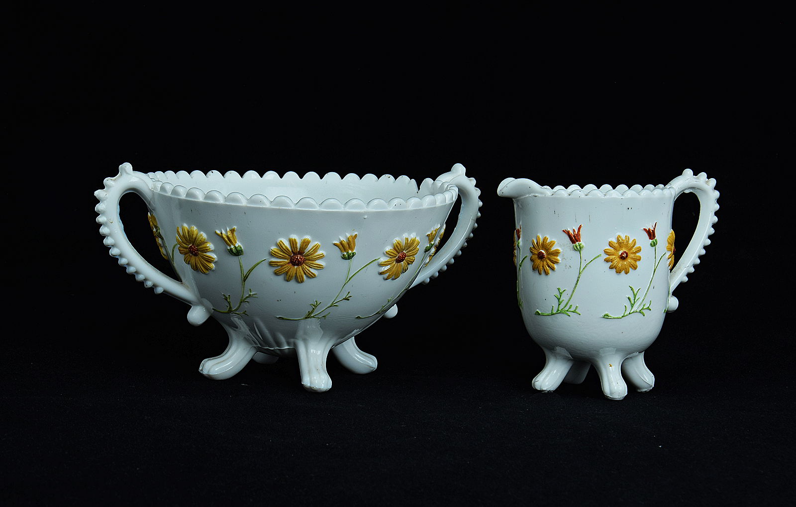 Sowerby opal white, cream jug and sugar bowl decorated with flowers picked out in red, mustard and green enamel