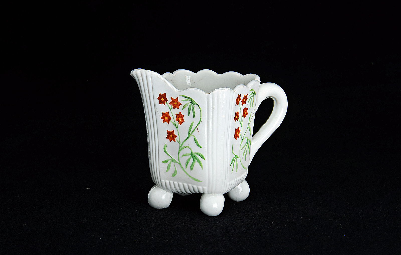 Sowerby opal white, cream jug with four ball feet decorated with flowers, flowers picked out in green and red enamel